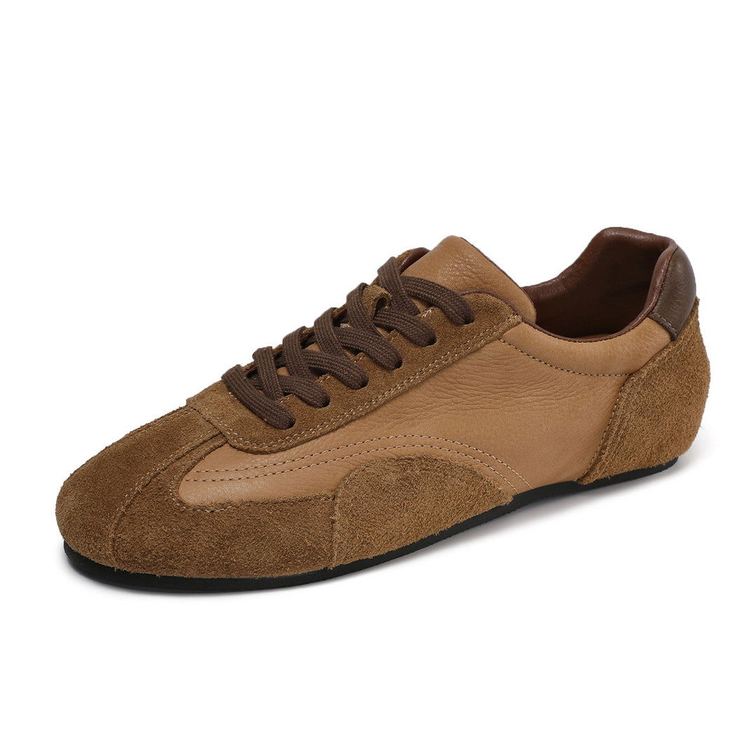 A low-top sneaker in tan and brown, featuring a mix of smooth leather panels and suede overlays, dark brown laces, and a black outsole, shown on a plain white background.
